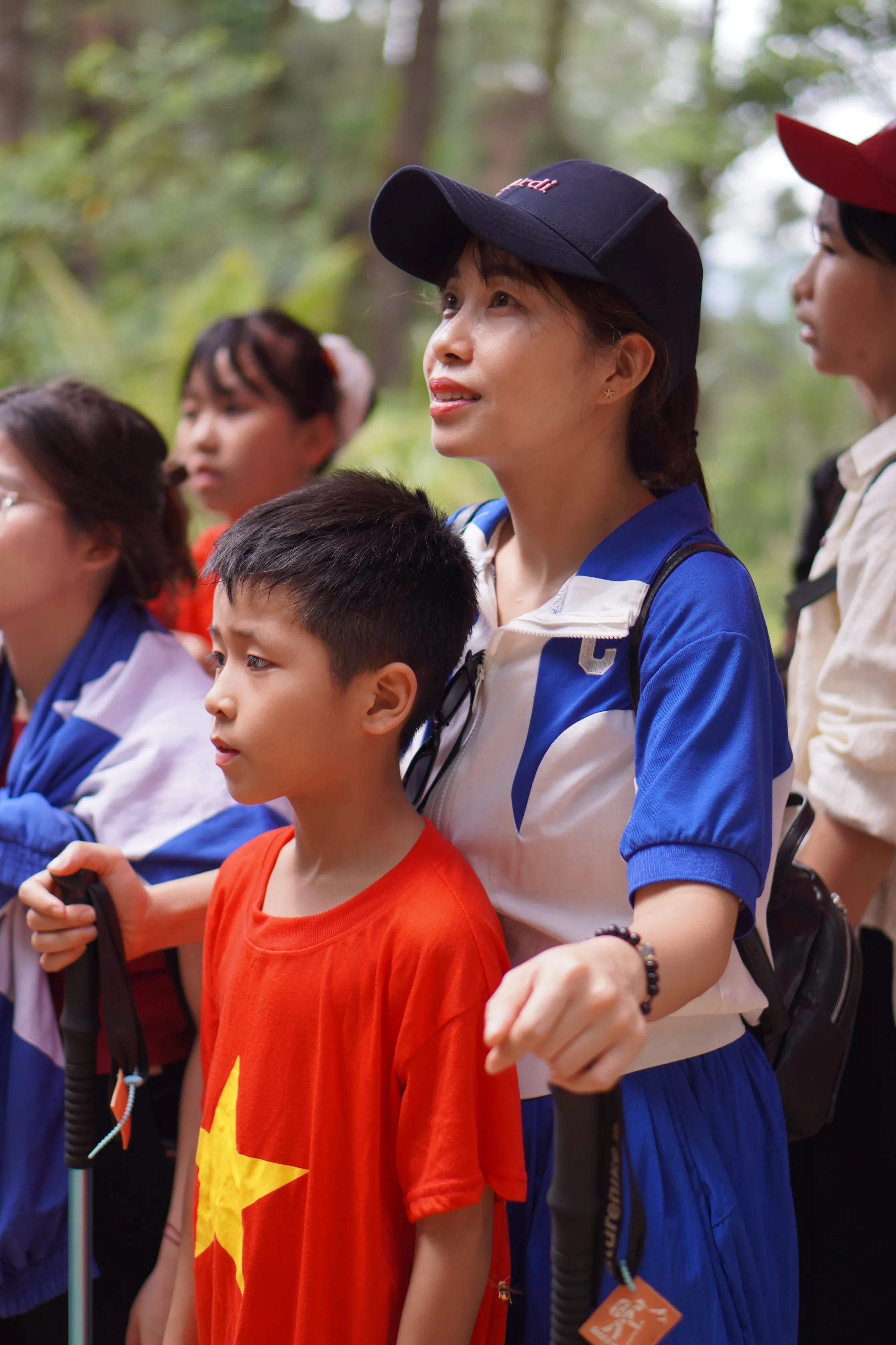 Nhóm người lớn và em nhỏ trong trang phục trekking giữa rừng