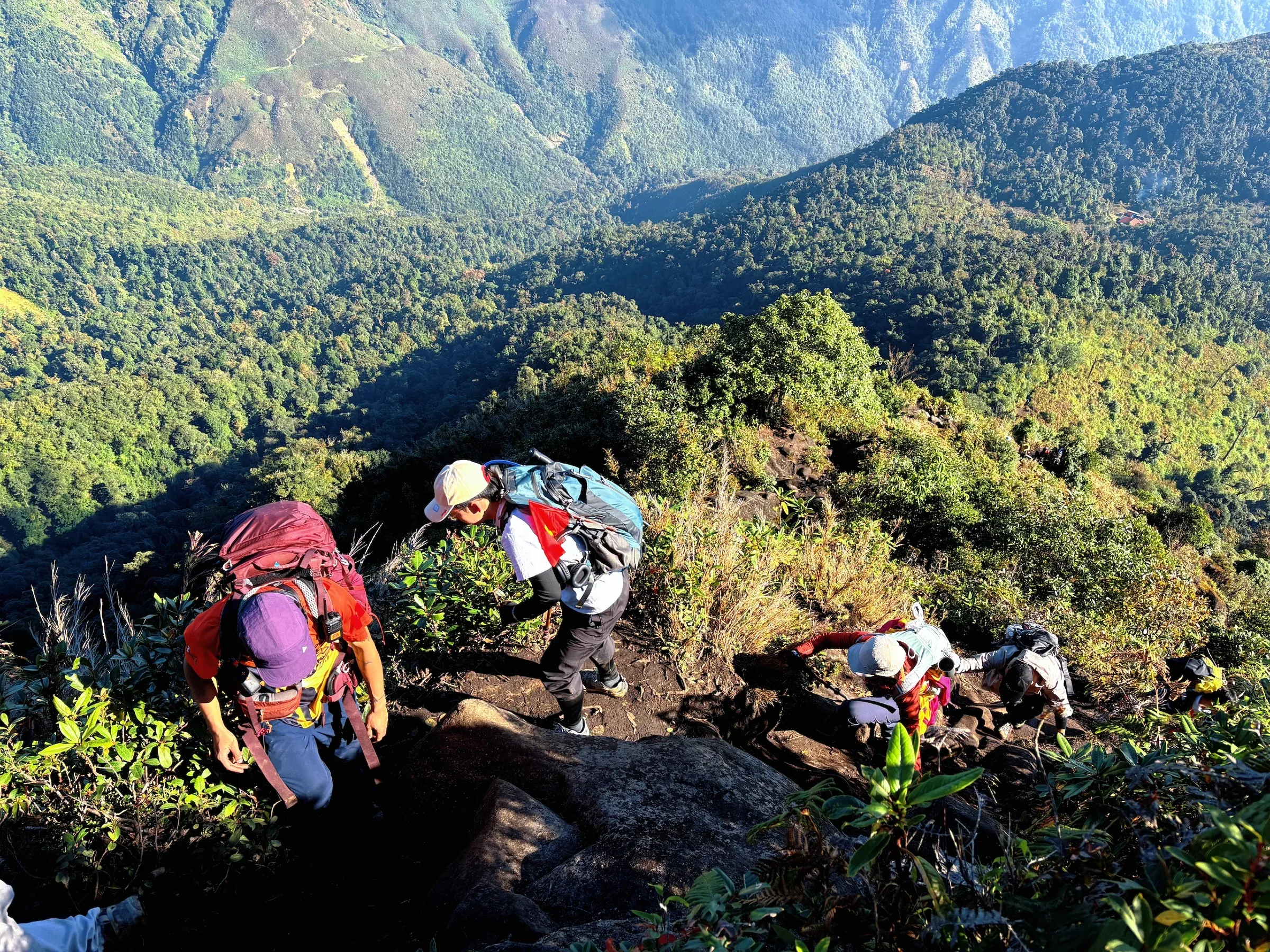 Đoàn trekking men theo đường mòn nhìn xuống thung lũng
