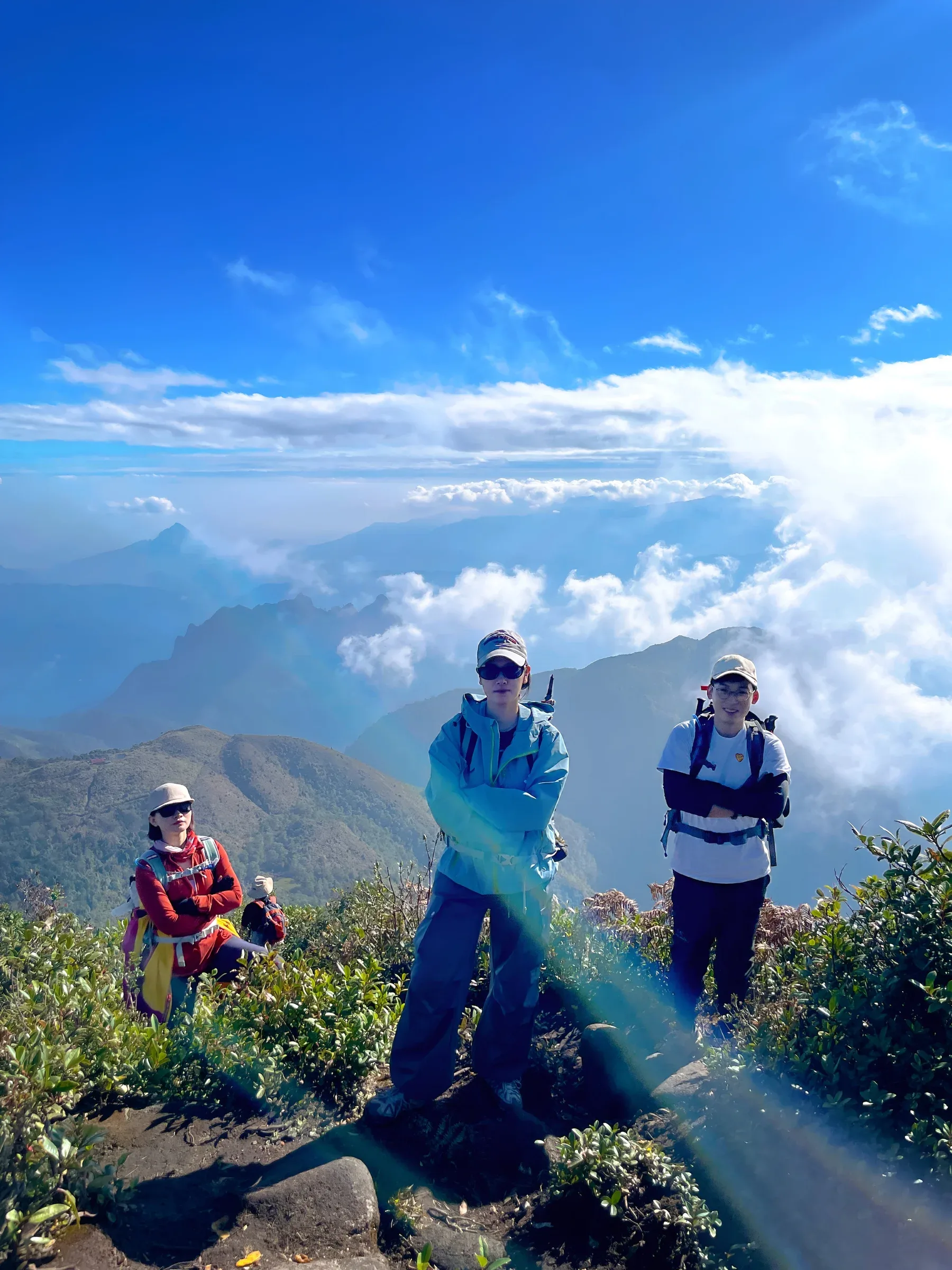 Nhóm du khách đứng trên đỉnh núi giữa mây trắng
