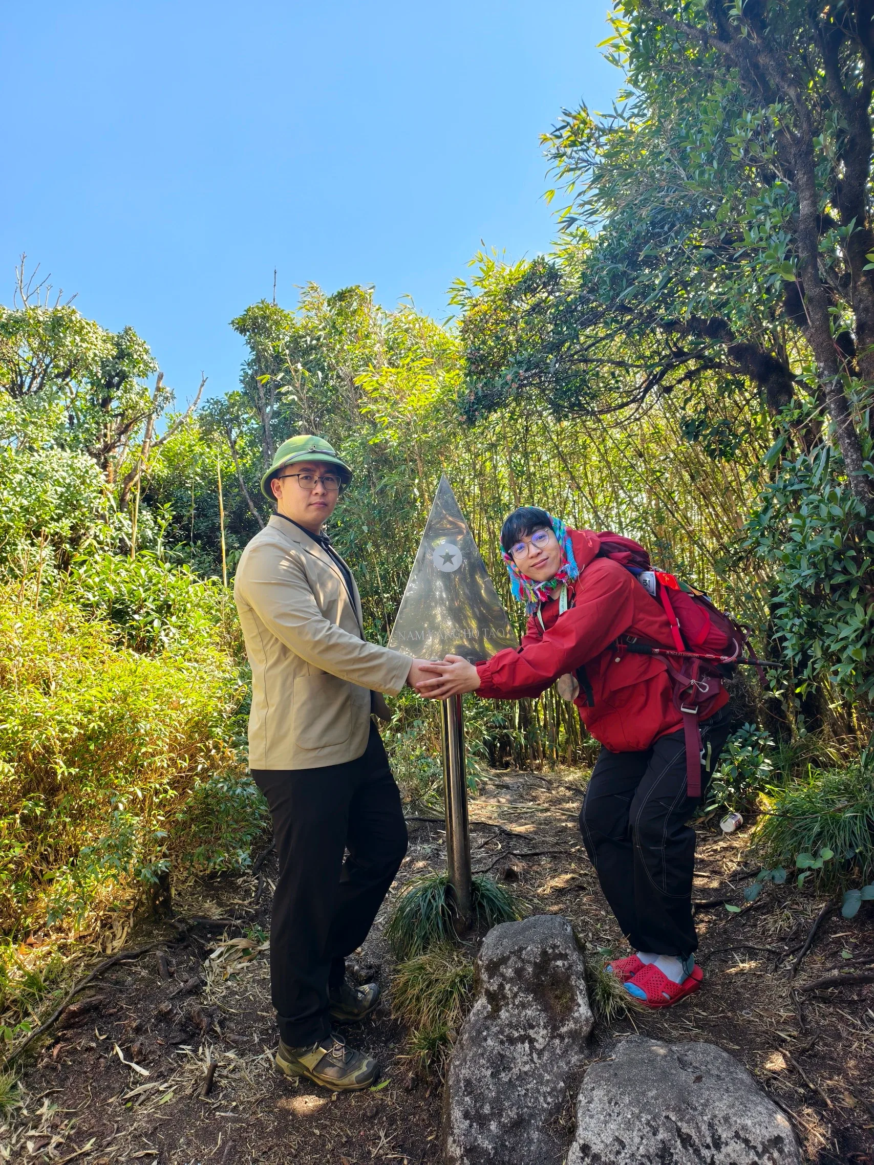 Hai du khách bắt tay hỗ trợ nhau trên đường trekking