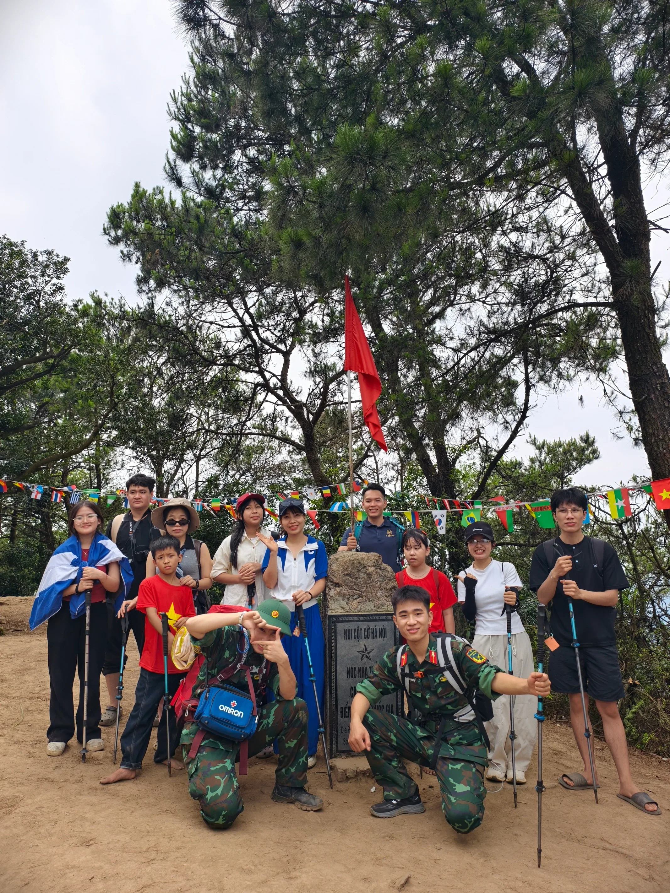 Đoàn trekking chụp ảnh tại cột mốc Nóc nhà Thủ đô dưới lá cờ đỏ