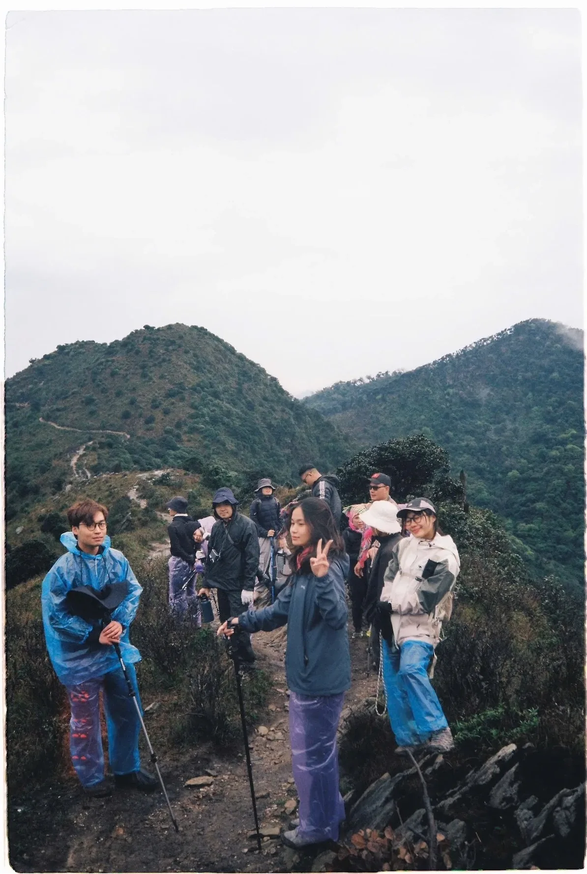 Đoàn trekking chụp ảnh trên sống núi dưới trời nhiều mây