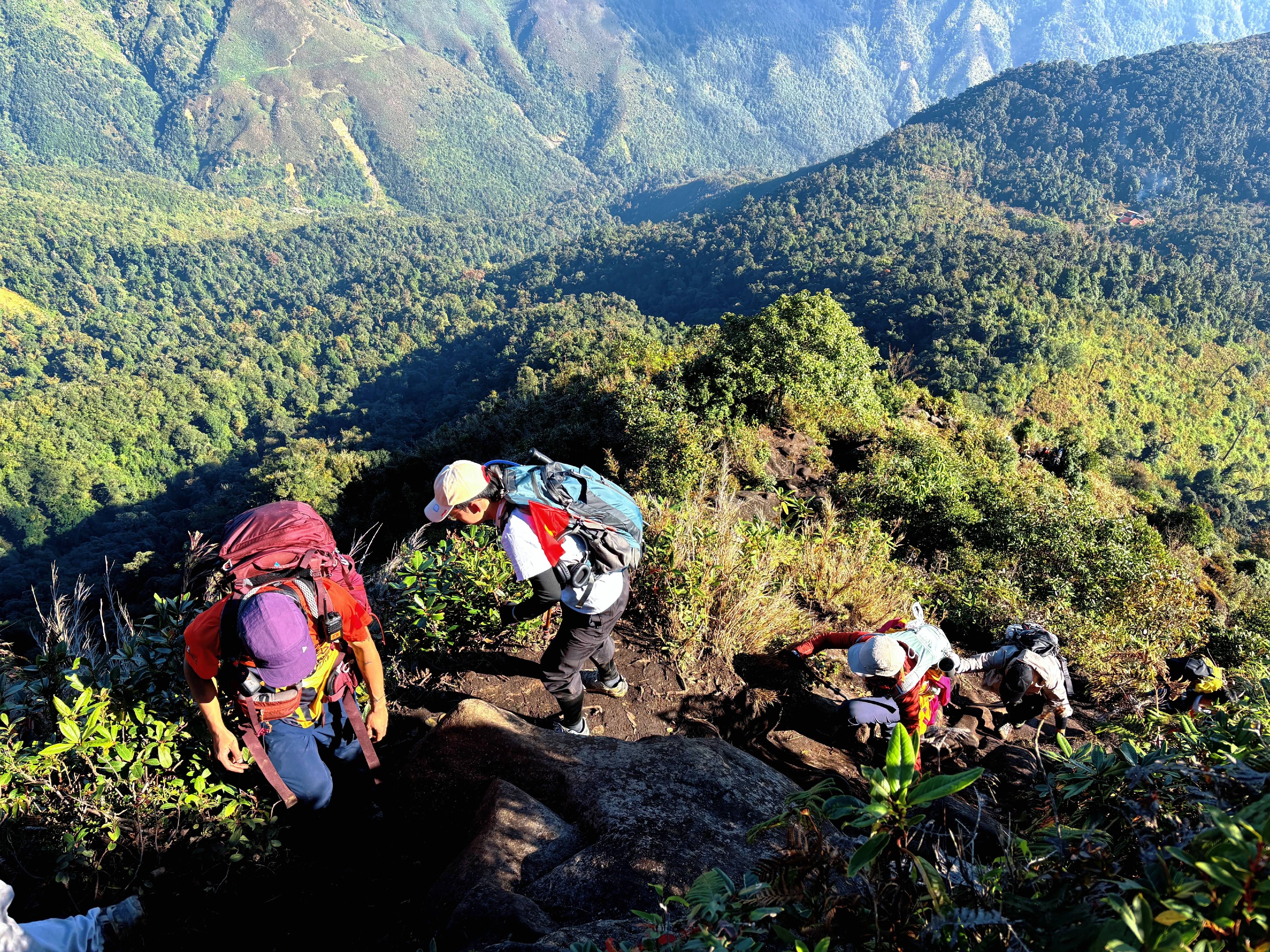 Đoàn trekking leo dốc đá trên đường mòn, băng qua rừng núi Kỳ Quan San