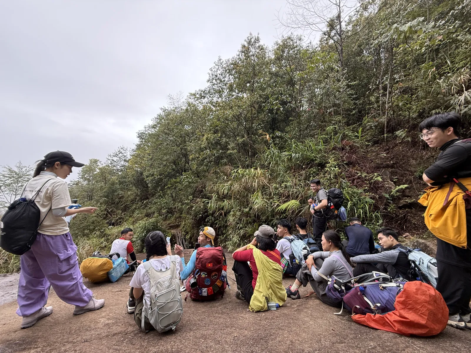 Đoàn trekking nghỉ chân trên đường mòn xuyên rừng, ba lô đầy đủ trang bị chinh phục Nam Kang Ho Tao